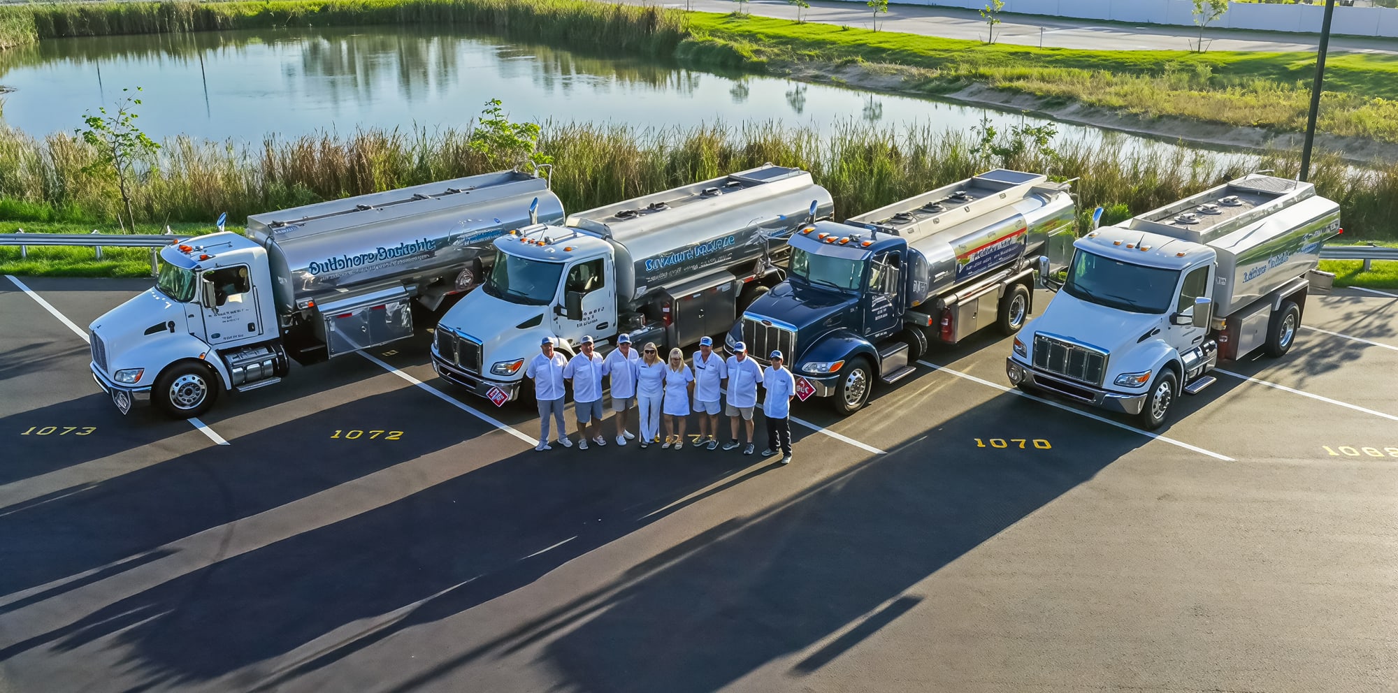 The whole crew standing in front of the tanker fleet at the Naples yard, seen from above, the blue Paradise Fuel tanker among them